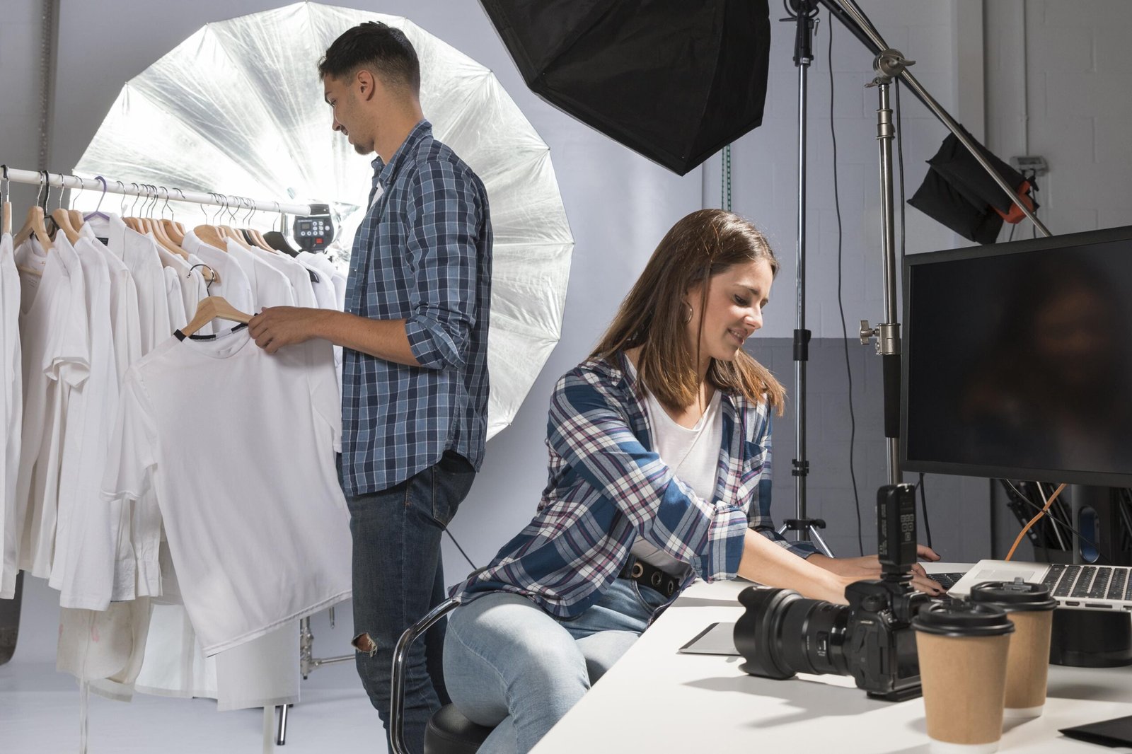 Equipo preparando sesión de fotografía de moda con iluminación profesional en estudio.